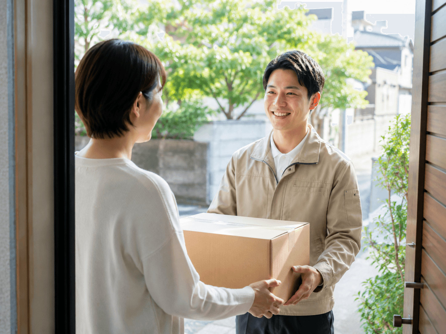 玄関先で荷物を丁寧にお届けする配送の様子